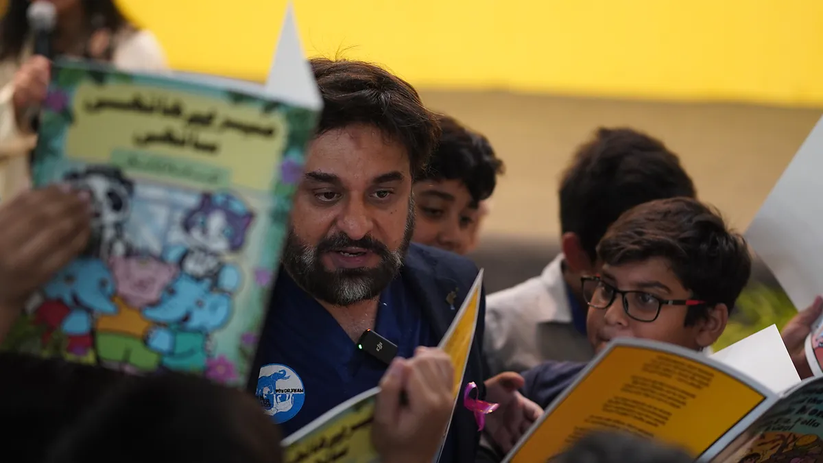 Dr Mohammad Muneeb Khan reading a KCK comic with students at Beaconhouse Educational Complex G-15.