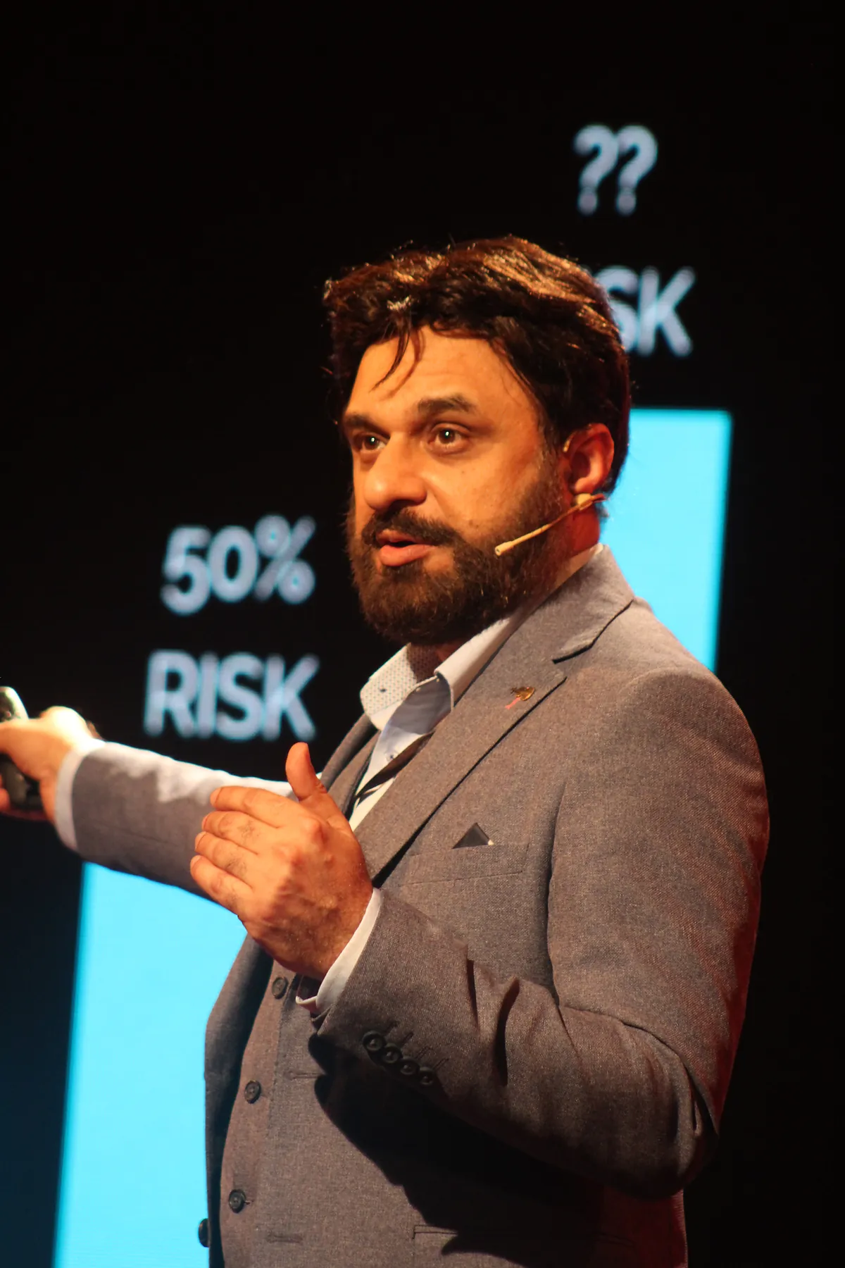Dr Mohammad Muneeb Khan on the TEDx stage in front of a slide reading 50% risk.