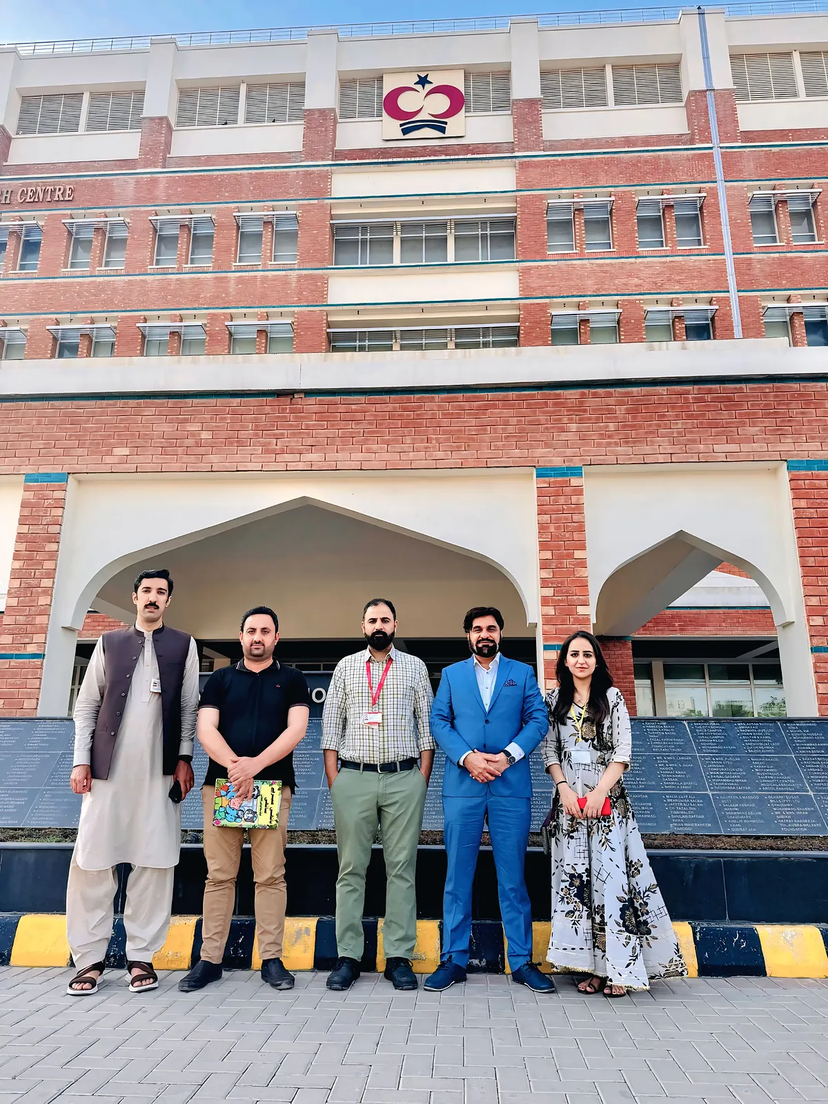 The Killing Cancer Kindly team with comics at the entrance to Shaukat Khanum Memorial Cancer Hospital in Peshawar.