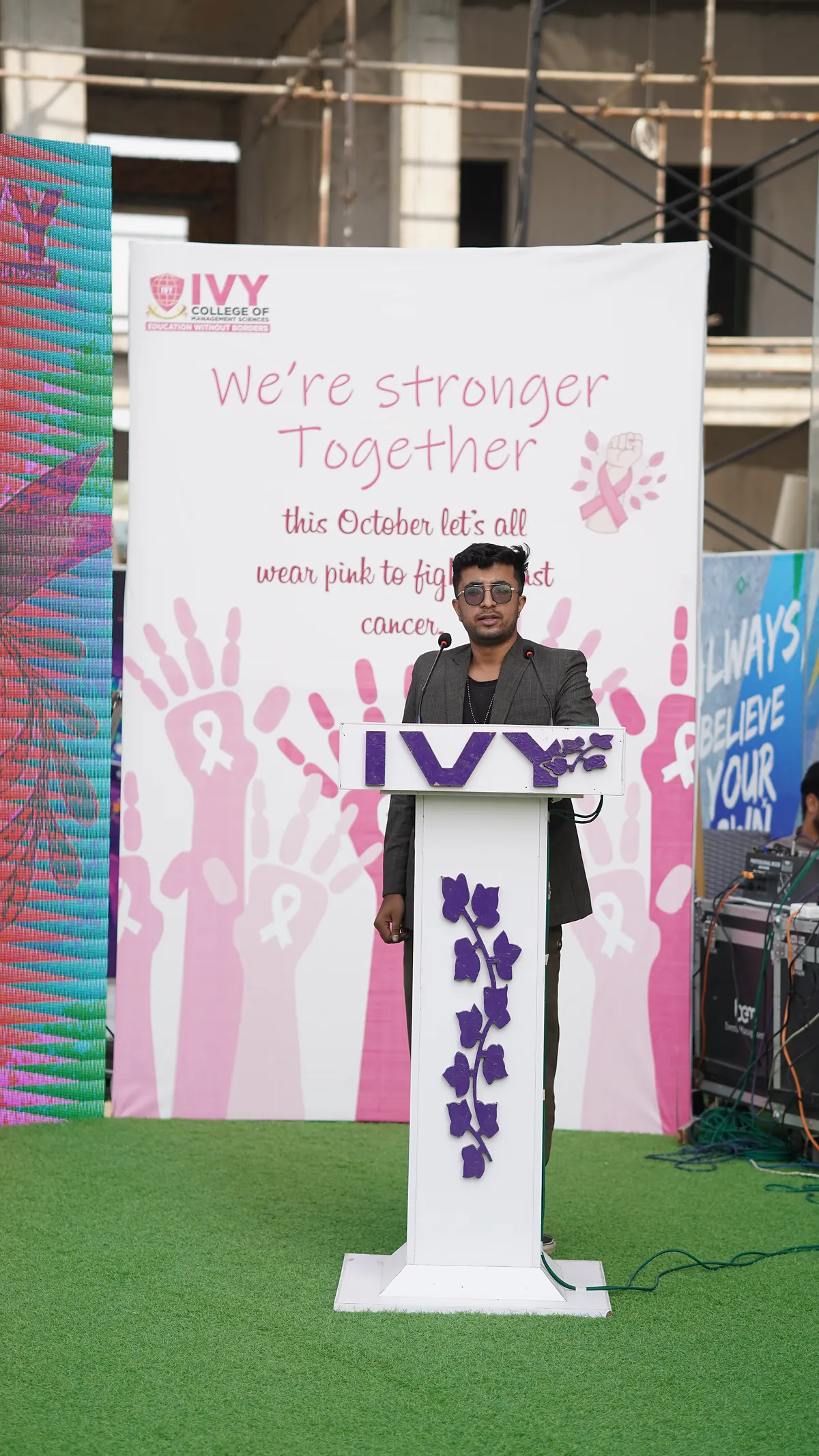Dr Mohammad Muneeb Khan at the lectern during Breast Cancer Awareness Month at Roots IVY International School H-8.